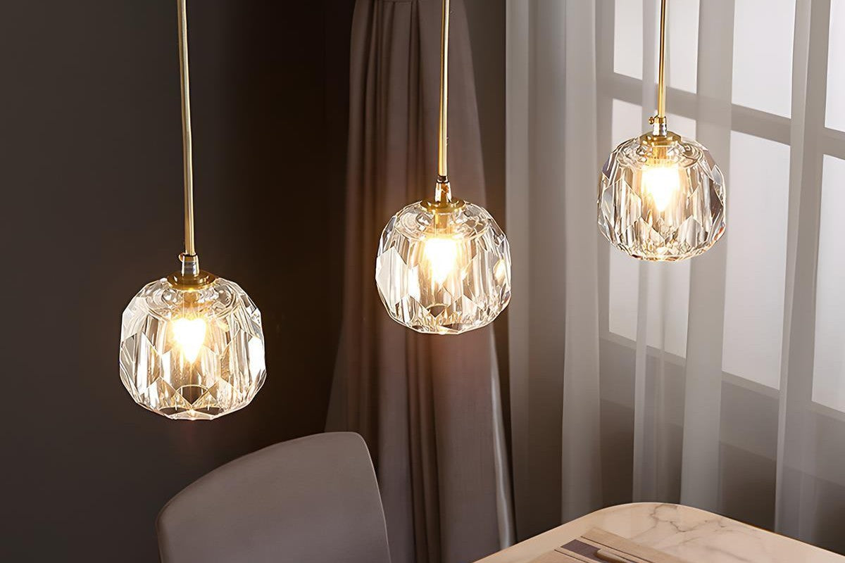 Three hanging pendant lights with glass shades in a room setting.